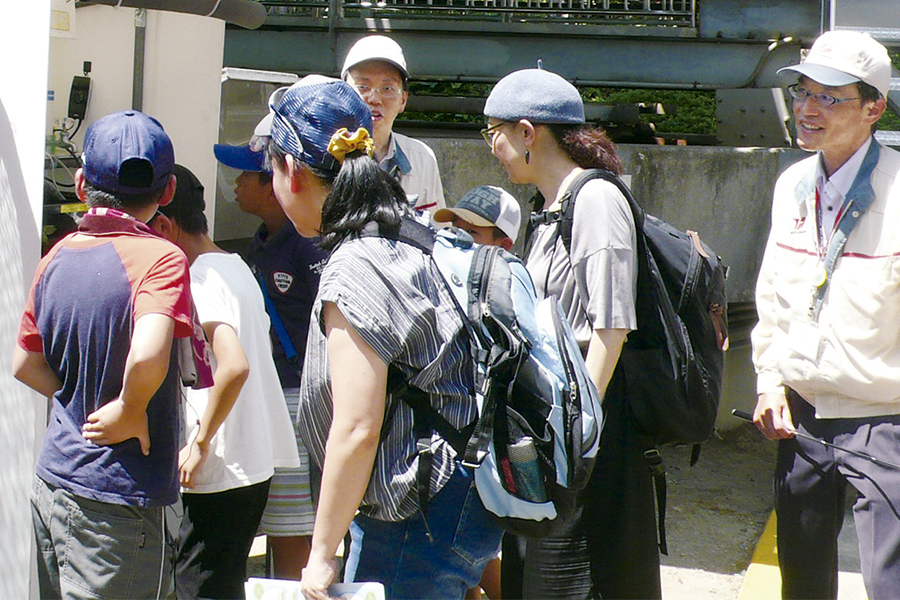 Photo:Parents and children observe killifish in a wastewater treatment facility as part of an eco-tour run by Toyota City.