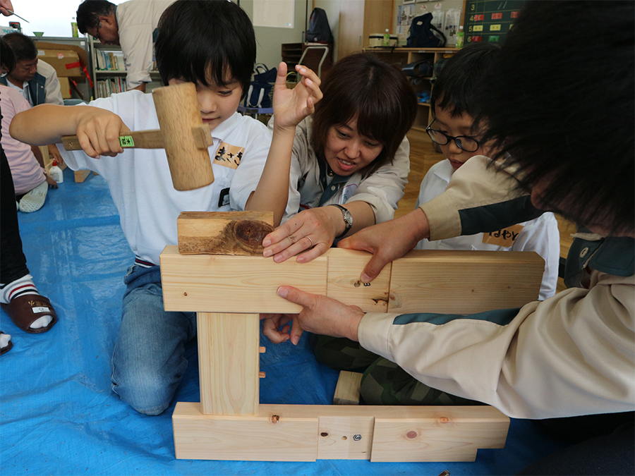 写真:児童と一緒にベンチの組立作業