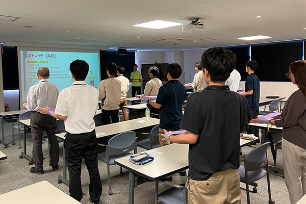 写真：参加者とゴムチューブを用いてストレッチを行いました